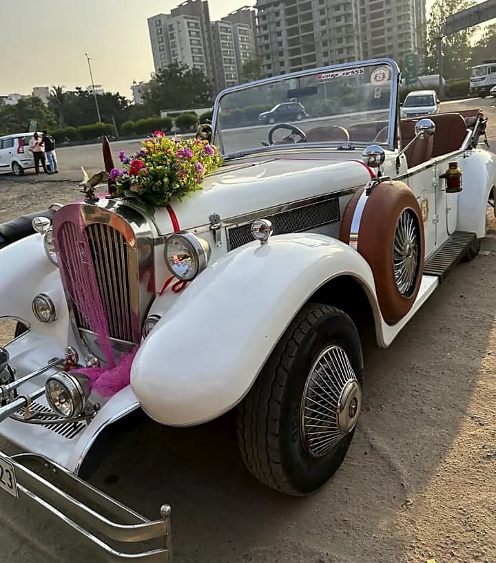 White open-top vintage car decorated with flowers